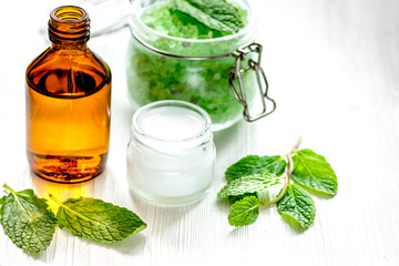 organic cosmetics with herbal extracts of mint on wooden backgro
