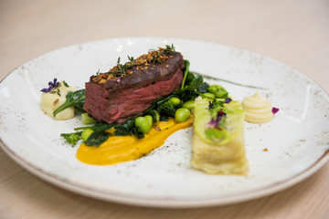 Beef meat with green peas, sweet potato mousse, roasted spinach and zucchini gratin