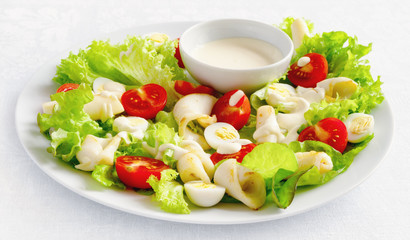 salad with seafood, lettuce, tomatoes, and quile eggs dressed with mayonnaise based sauce 