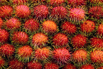 Obraz premium rambutan fresh, rambutans fruit many for background, rambutan sweet delicious fruit, red healthy fruits rambutan, rambutans sweet fruit at thai asia local market street fruit