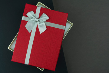Open Red gift box with bow on black and grey background