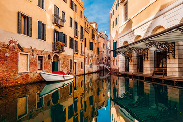 Fototapeta na wymiar Small canals boats, old brick houses Venetian style Venice, Italy.