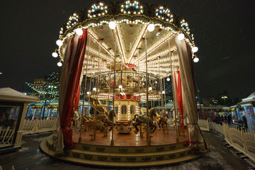 New Year's atmosphere in the Red Square. The city is brightly decorated and lit with garlands. Children are happy, here merry-go-round horse carousel giving fun. © Yury and Tanya