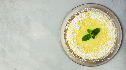 Healthy dessert - raw vegan lemon and coconut cake on grey background - gluten free, lactose free