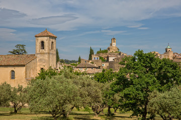 Fototapeta na wymiar Idyllic Lourmarin. Belfry of the Protestant Church and Clock Tower in the Village of Lourmarin, Provence, Luberon, Vaucluse, France
