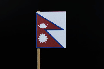 A unique and official flag of Nepal on toothpick on black background. A combination of two red pennons with the large blue border around the unique shape of two overlapping right triangles.