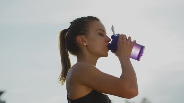 Athletic girl drinking water