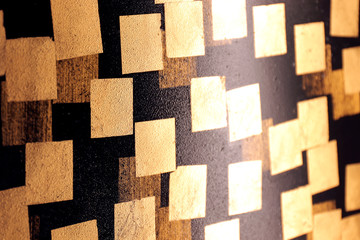 gold plate on wall black, gold leaf, golden square foil on black background, black tile wall with gold plate abstract texture, foil golden decoration architecture decor wallpaper (selective focus)