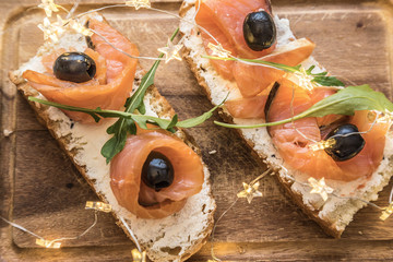 Healthy snack or salmon fish, arugula, olives and creamy cheese on toast bread. French or italian...
