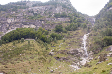Water Fall and Small River in the Swiss Alps during Cloudy Day