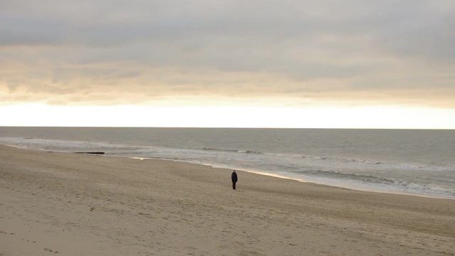 Strand mit einsamer Person am Horizont