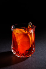 Red drink in a crystal glass. Photo of a drink on a black background.