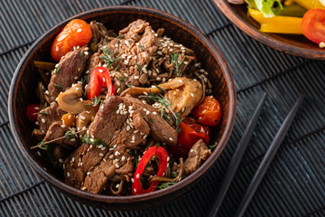 Soba noodles with beef, mushrooms, cherry tomato and sweet peppers. Asian cuisine