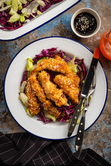 Salad with warm glazing chicken, sprinkled with sesame seeds. Chinese cuisine. Asian culture