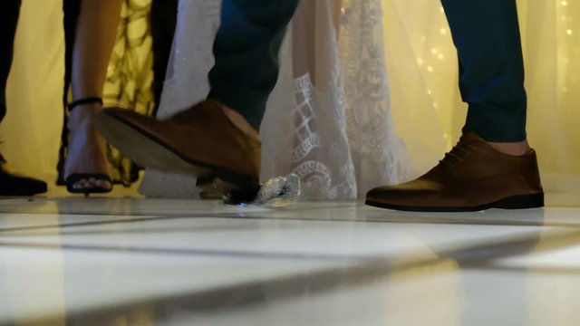 Shot video HD the groom on a hupa breaks a glass.