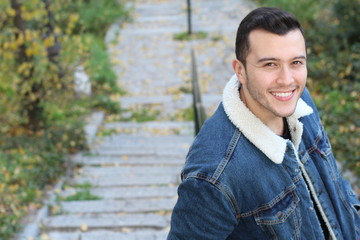 Natural ethnic man smiling outdoors with copy space