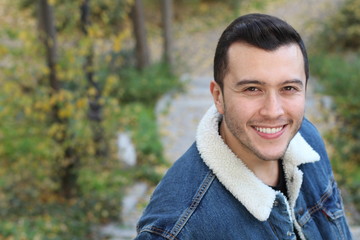 Natural ethnic man smiling outdoors with copy space