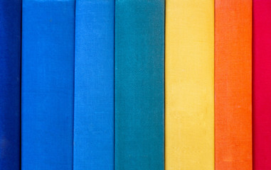 A stack of colorful rainbow books, arranged vertically. trend background. Close-up of book stubs. education concept.