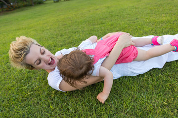 mother and little daughter playing at backyard