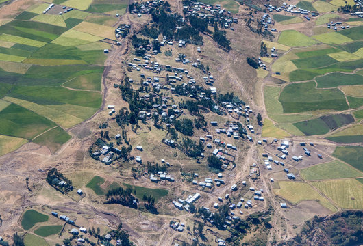 Aerial view of village surrounded by green farmland in Ethiopia.