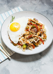 Udon stir-fry noodles with chicken on concrete background