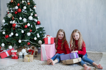 Obraz na płótnie Canvas two blonde girlfriends sisters girls Christmas presents new year tree