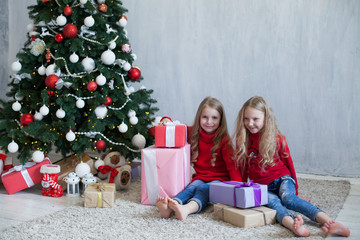 Fototapeta na wymiar two blonde girlfriends sisters girls Christmas presents new year tree