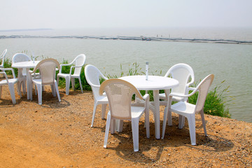 White plastic tables and chairs on the dam