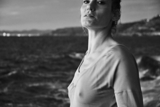 Woman taking off sweater near sea
