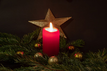 Christmas impressions with candle, fir branches, christmas decorations and christmassy pastries