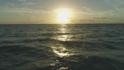 Low Level Flight over Sea at Sunrise. Aerial View