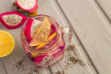Detox water with dragon fruit,chia  and lemon on the grey wooden background.Top view.Copy space.