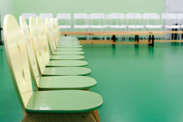 Obraz premium Children's wooden chairs, white chairs and wooden benches in the room for viewers of a children's holiday