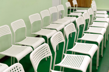 New white chairs  are in the room for the audience of children's holiday