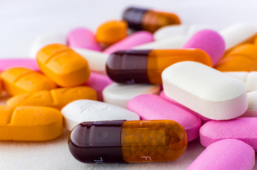 Close up colorful pills background. Medicine pills, tablets and capsules different colors on white background.