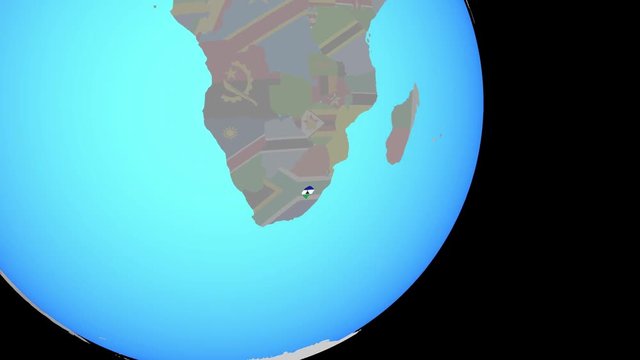 Zoom to Lesotho with embedded national flag on blue political globe. 3D illustration.