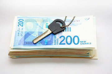house key on money pile- with israeli shekels