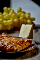 Traditional bread pita or khachapuri on the table with herbs. Homemade baking recipe.