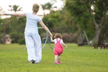 mother and little daughter playing at backyard