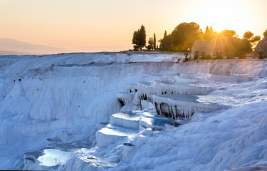 Pools of Pamukkale in Turkey in sunset, contains hot springs and travertines, terraces of carbonate minerals left by the flowing water, UNESCO World Heritage Site