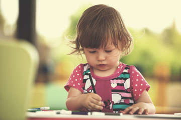 little girl drawing a colorful pictures