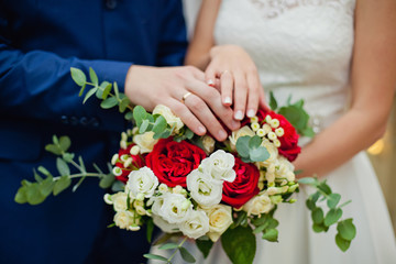 wedding bouquet in hands of bride and groom