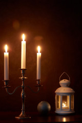 quiet home environment at night by candlelight. White candles burn in the dark. peaceful composition.