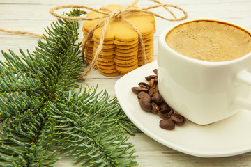 Obraz na płótnie Canvas Coffee and ginger biscuits with spruce branches on a wooden background, hearty and healthy breakfast