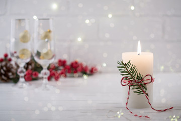 Christmas home decoration. Burning white candle and Christmas interior red decorations on table