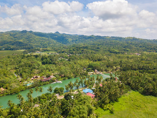 Aerial drone view to Loboc river. Mountain river flows through green forest. Bohol island, Philippines