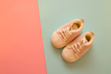 Pink sneakers little girl on a pink and blue background. Pastel colors.