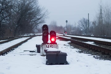 Semaphore on the railway in winter, glowing red. Gloomy scene