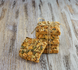 A stack of shortbread cookies with different types of nuts to a delicious coffee or tea on a light wood table. vertical view. light background. large. minimalism with baking.