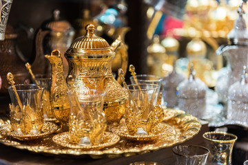 Traditional tea sets at Grand Bazaar in Istanbul, Turkey. Golden color teapot and Turkish tea cups..